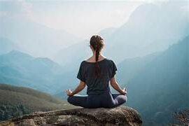 persona sentada en una montaña meditando que beneficios tienen los masajeadores